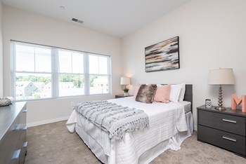 Millside bedroom with large open windows and plush carpet
